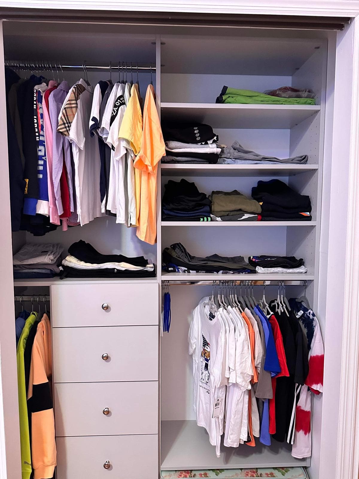 White reach-in closet with hanging zone, shelves, and 4-drawer base