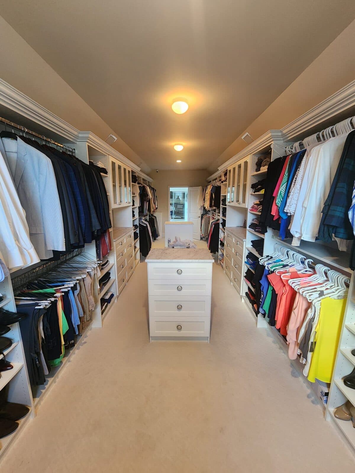 Walk-in closet with marble-top center island, 4-drawer base, and dual-side hanging