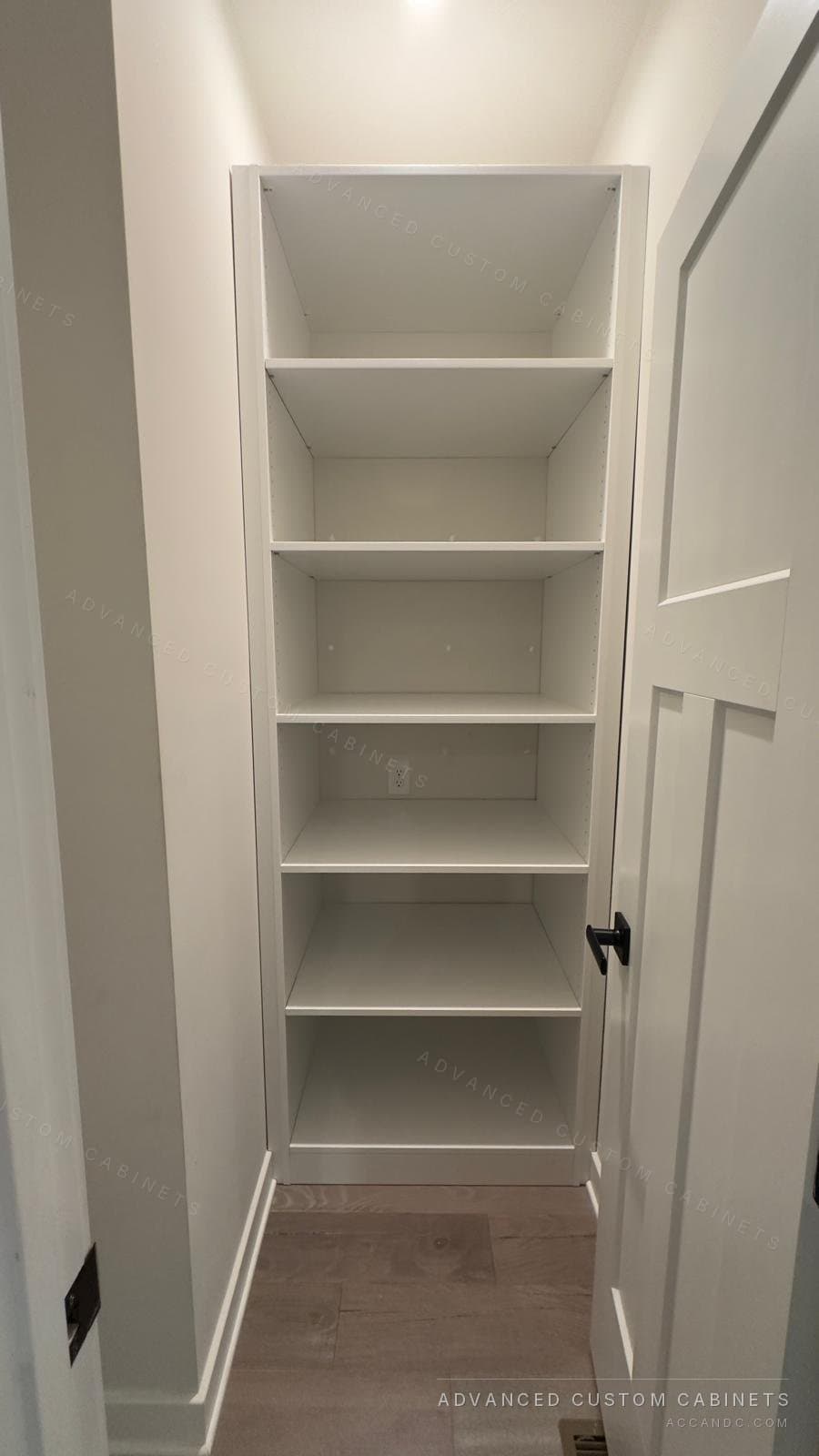 Narrow white reach-in closet fitted floor to ceiling with adjustable open shelves