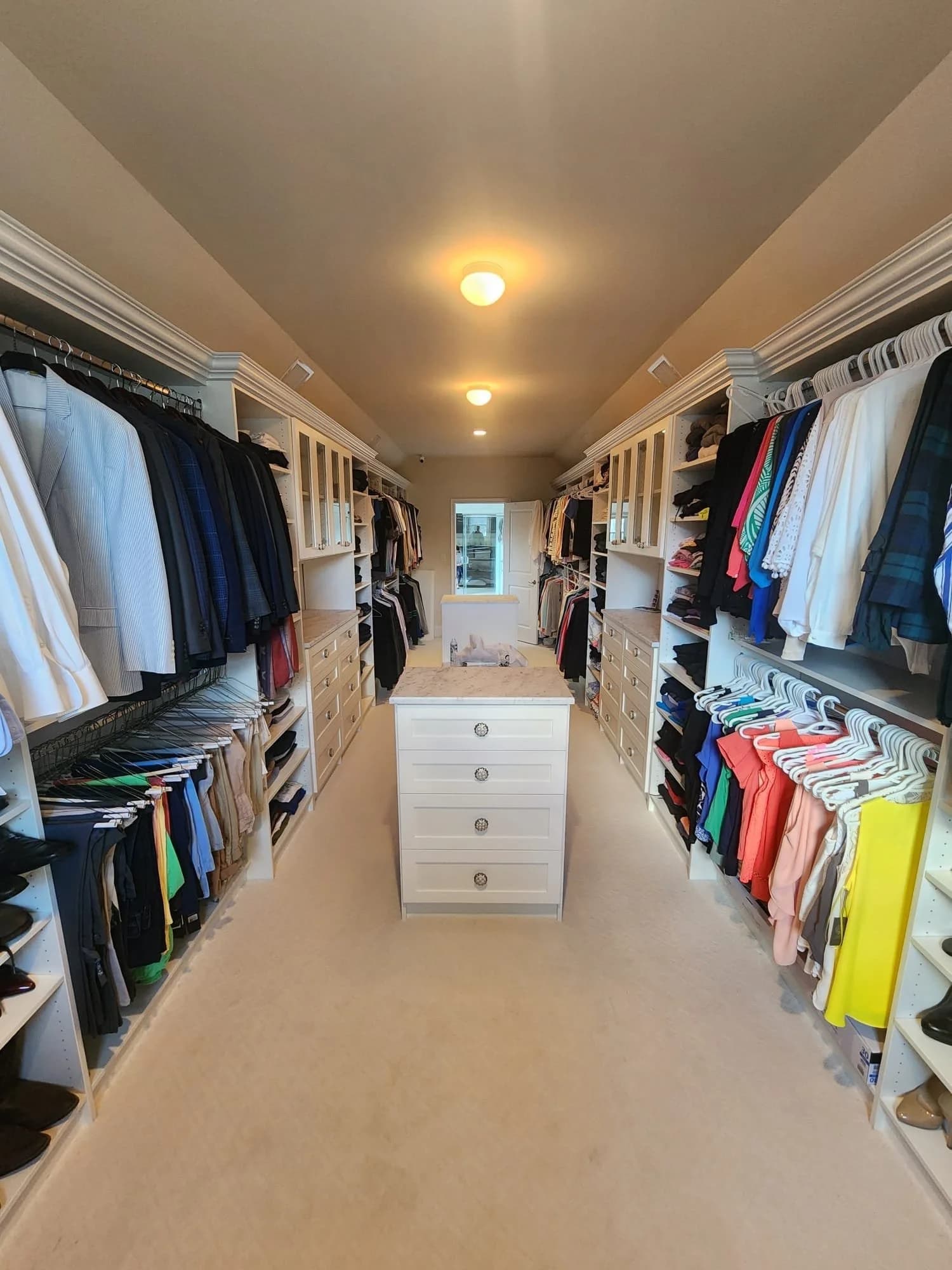 Spacious walk-in closet with island and drawers